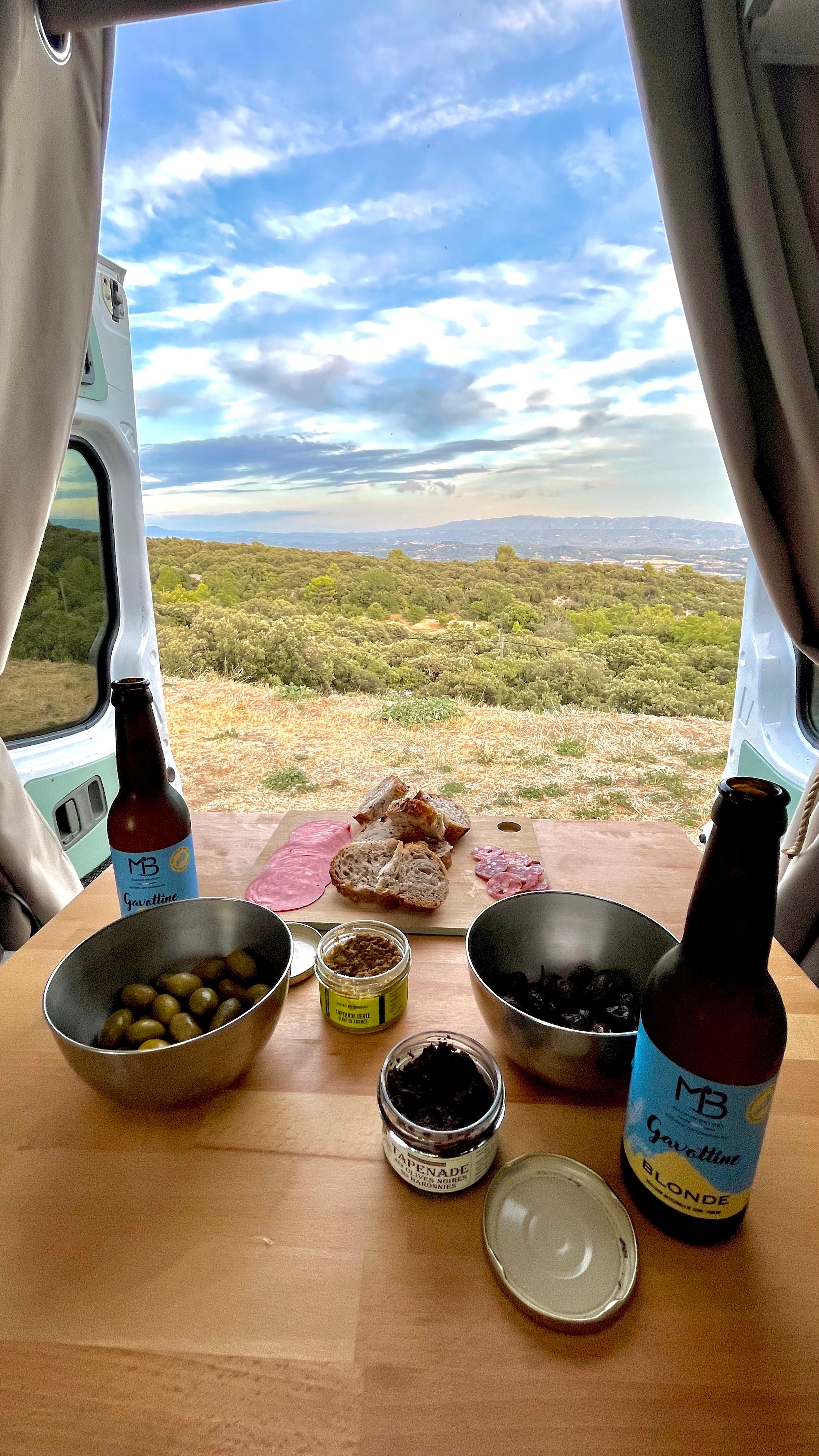 Un apéro dans un van avec une vue sur le Lubéron depuis un parking près de Gordes