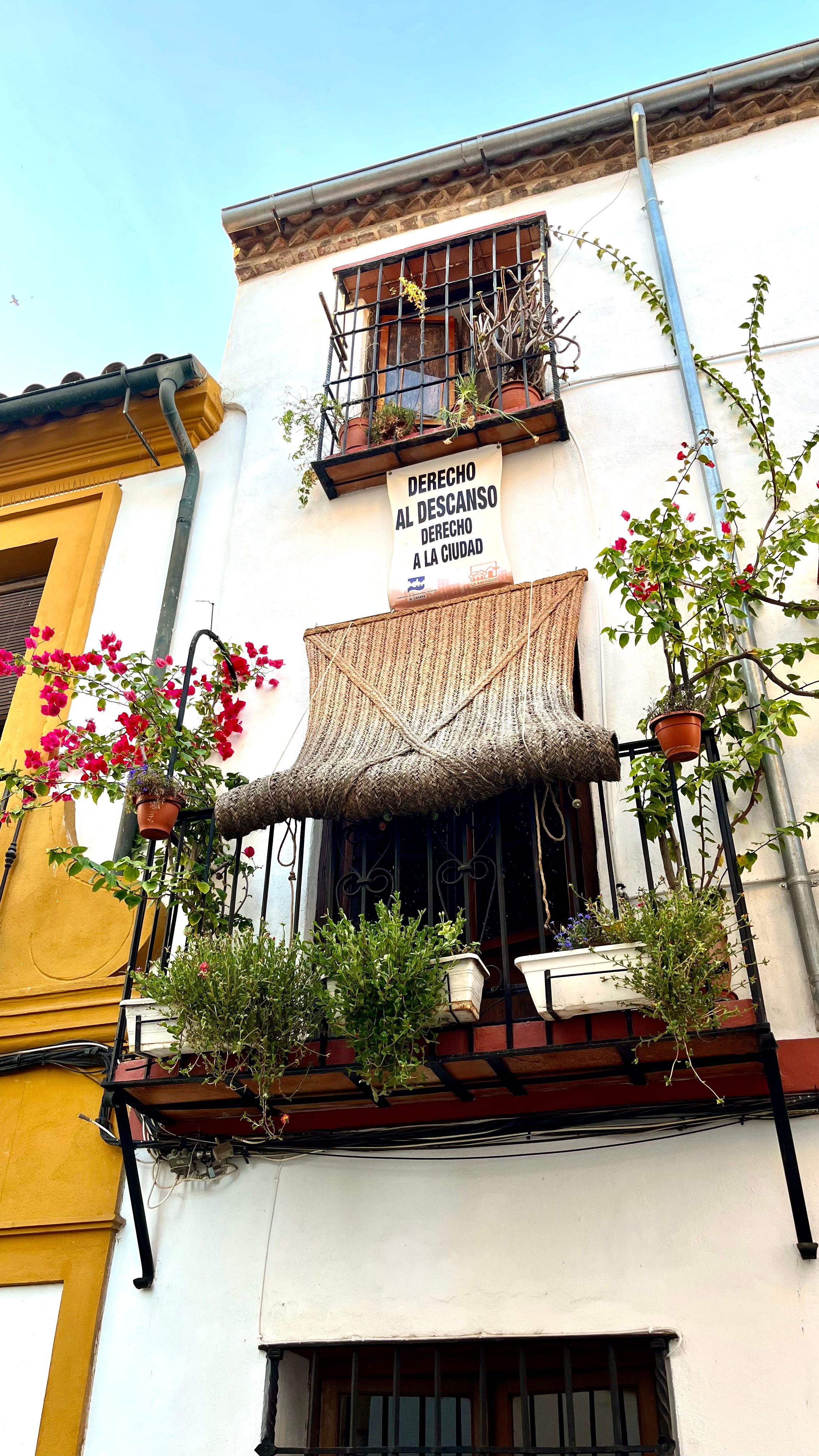 Un balcon fleuri avec une affiche dans les rues de Cordoue en Andalousie