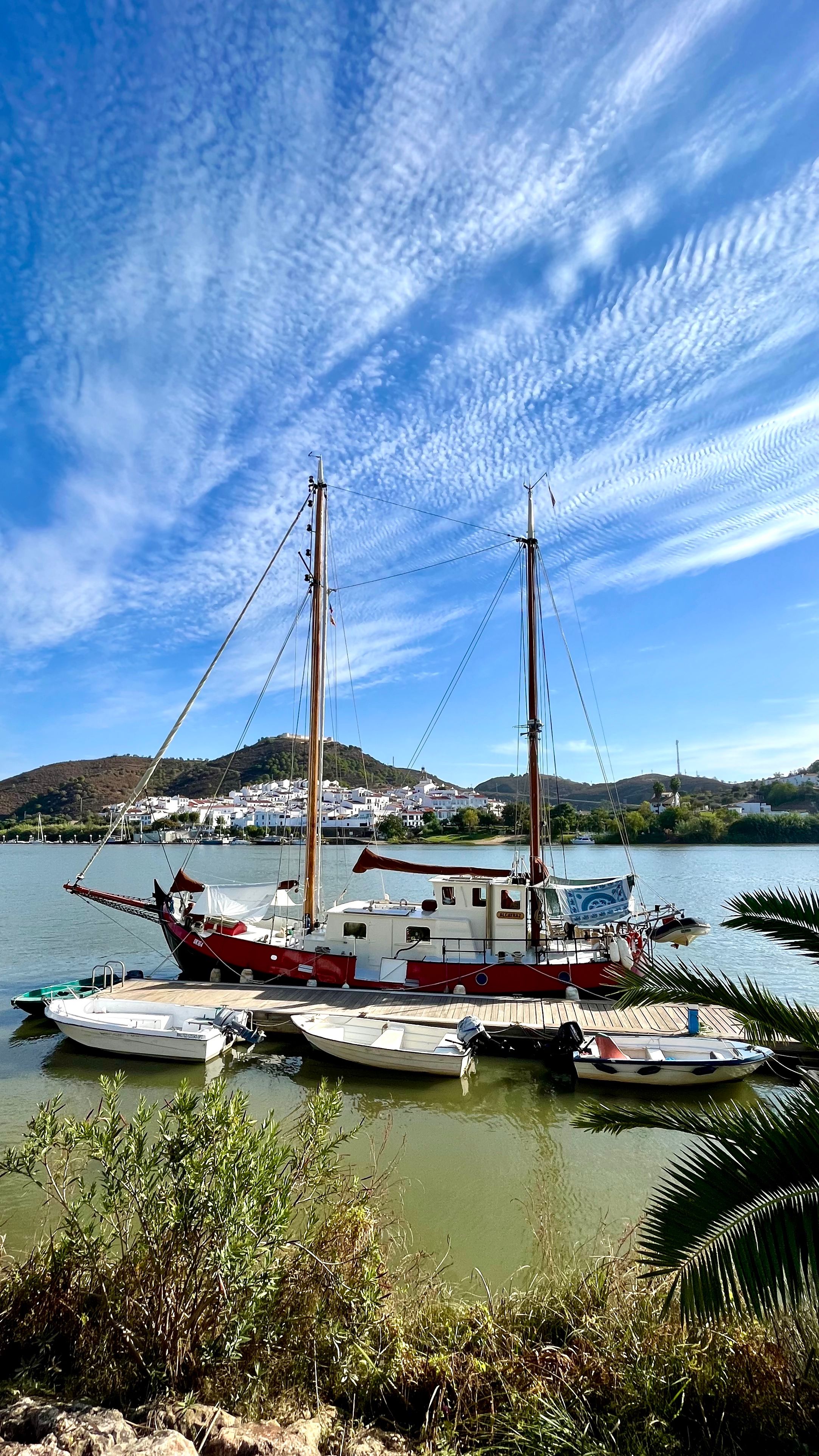 Vue sur un village blanc d'Espagne avec le fleuve et un bateau au premier plan