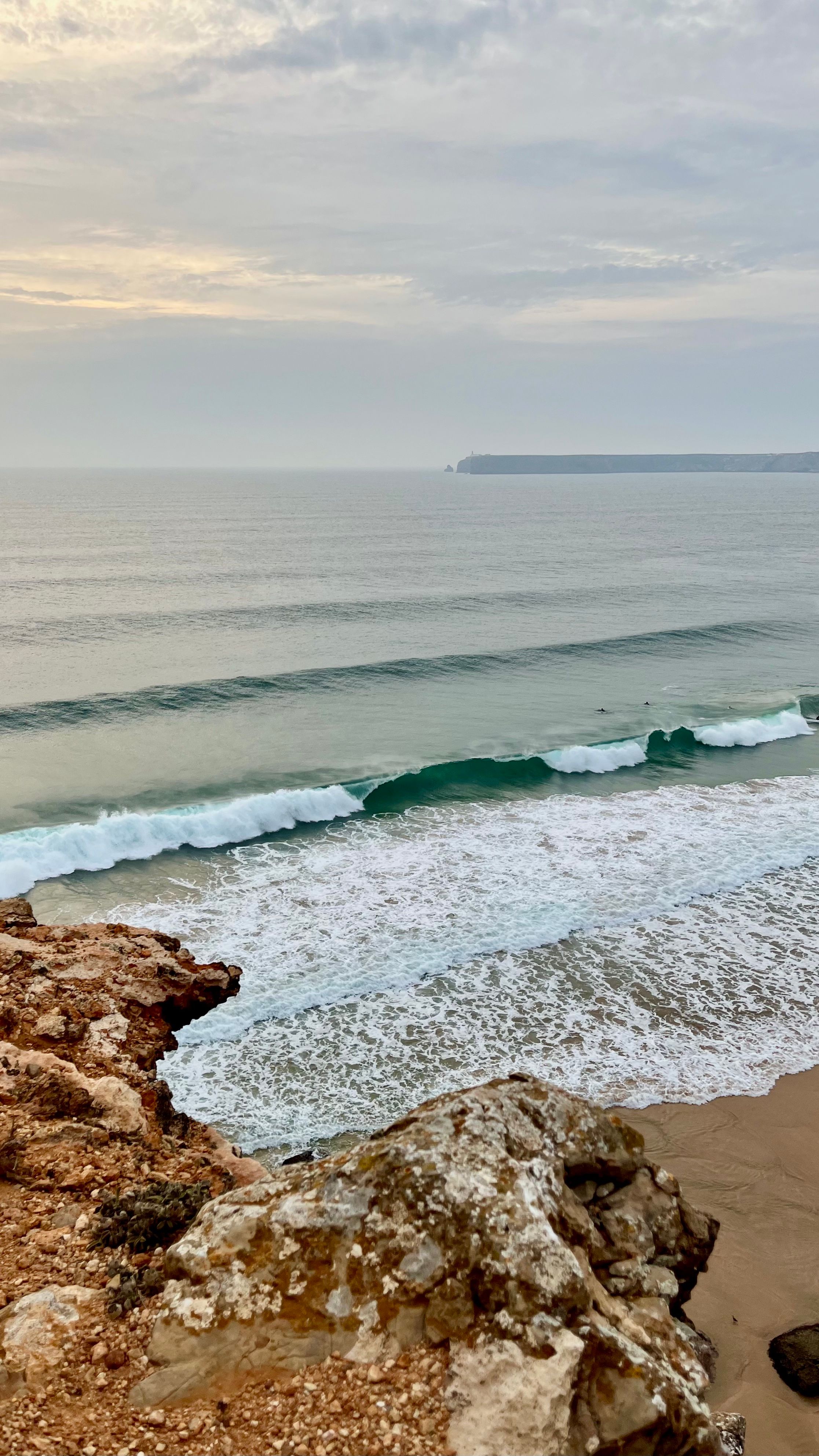 Une plage de Sagres avec en fond le Cap St Vincent en Algarve